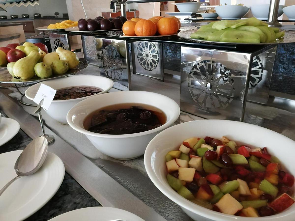 منتجع توليب الجلالة ماجستيك عين السخنة المظهر الخارجي الصورة The photo shows a buffet-style arrangement of various fruits and fruit dishes. In the foreground, there are several bowls containing different types of fruit. One bowl has a fruit salad made with diced apples, green apples, and possibly other fruits.